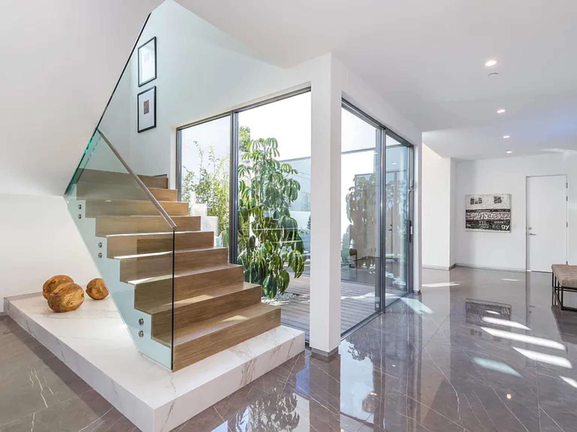 Formosa Residence — glass-railed stair beside full-height glazing